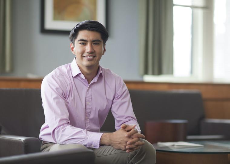 A man student sitting on a couch.