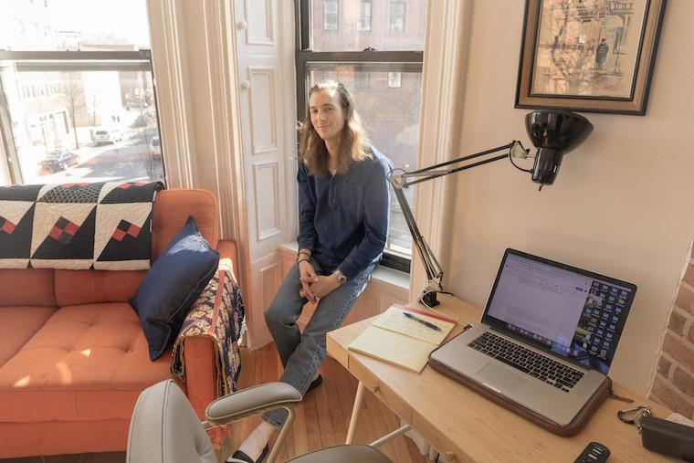 Man sitting next to a computer in his apartment.
