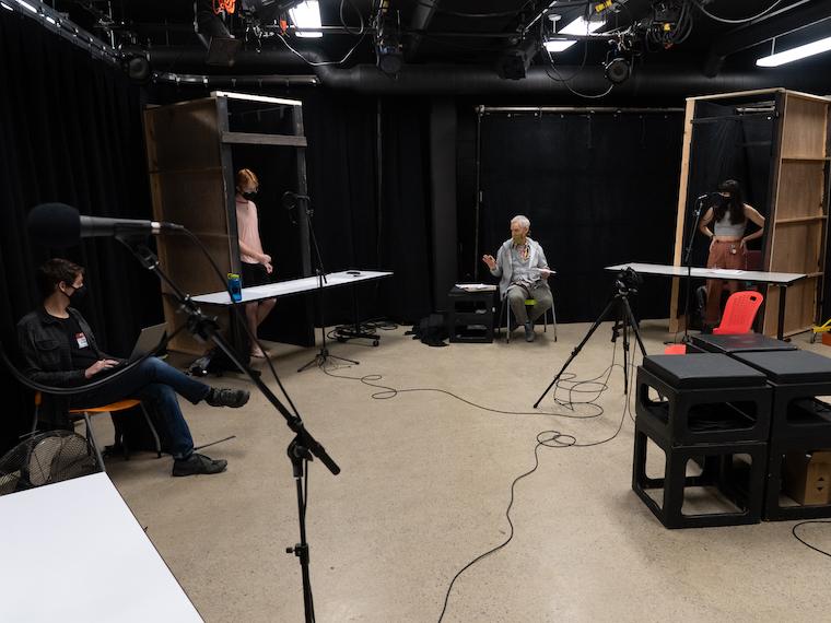 four pepple spread out in a room making an audio recording.