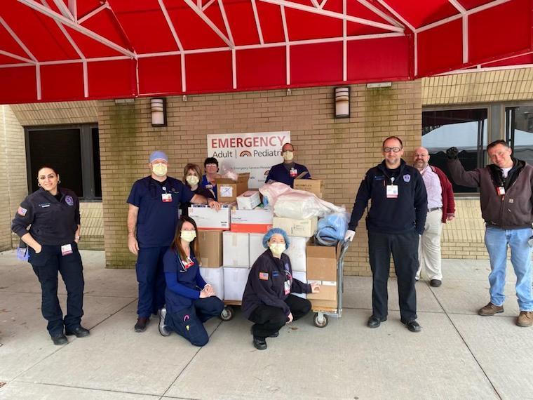 People receive cart of donations outside emergency room.