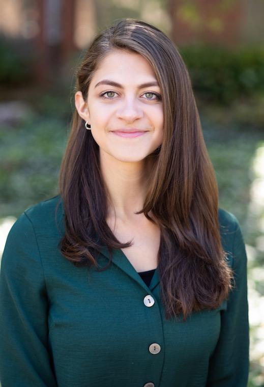 Woman smiling while standing outside.
