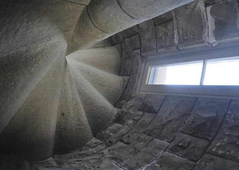 A stone room with rounded walls and window.