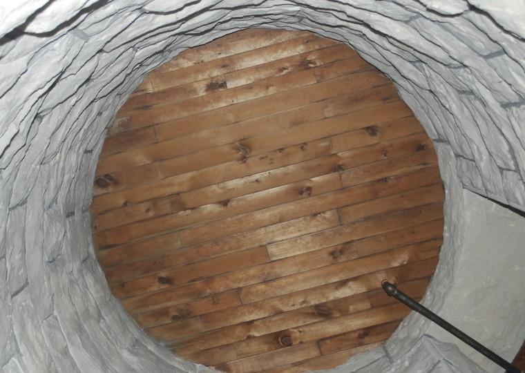 A round stone wall with a wooden floor.