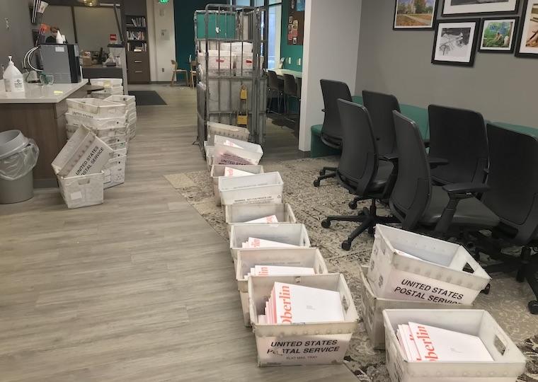 Plastic bins are in piles on the  floor.