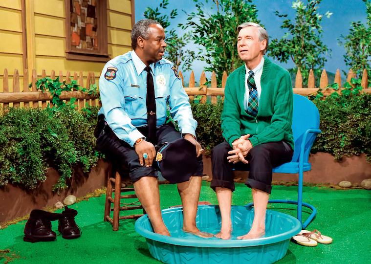 Two men sit with their feet in a child's pool.