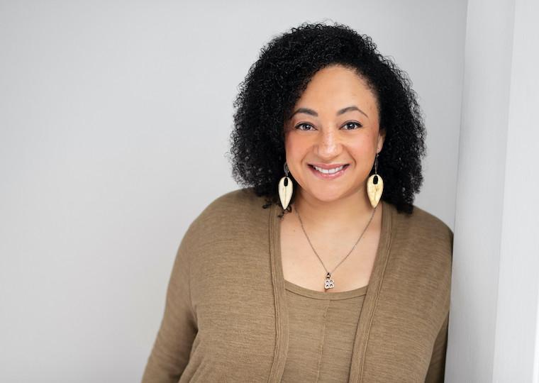 Portrait of a lady leaning against a wall.