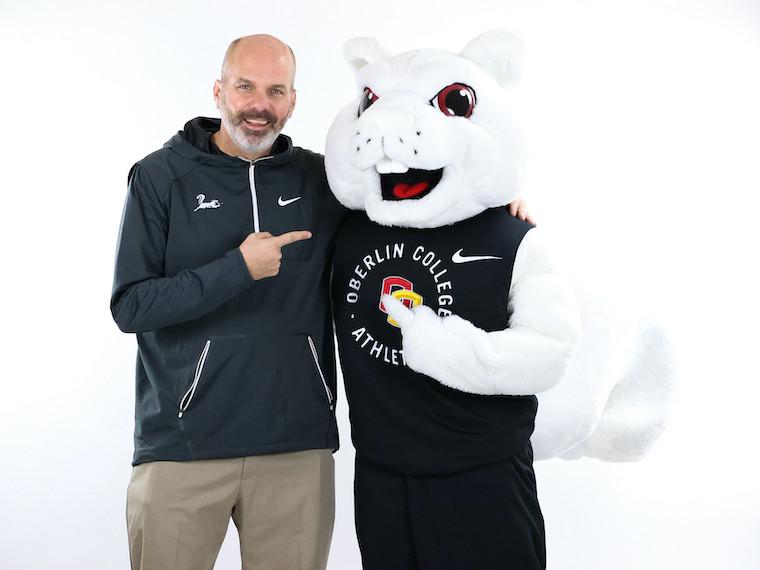 A man poses with a person wearing a large squirrel costume,