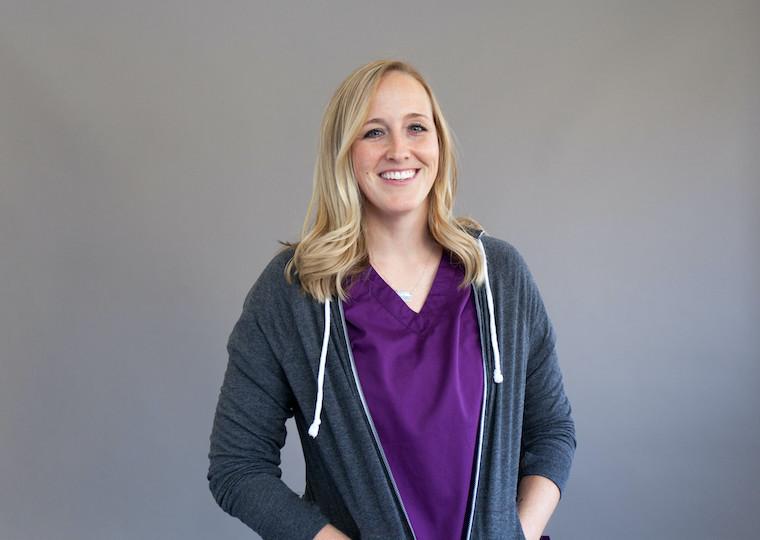 A portrait of a woman wearing a hoodie and scrubs.