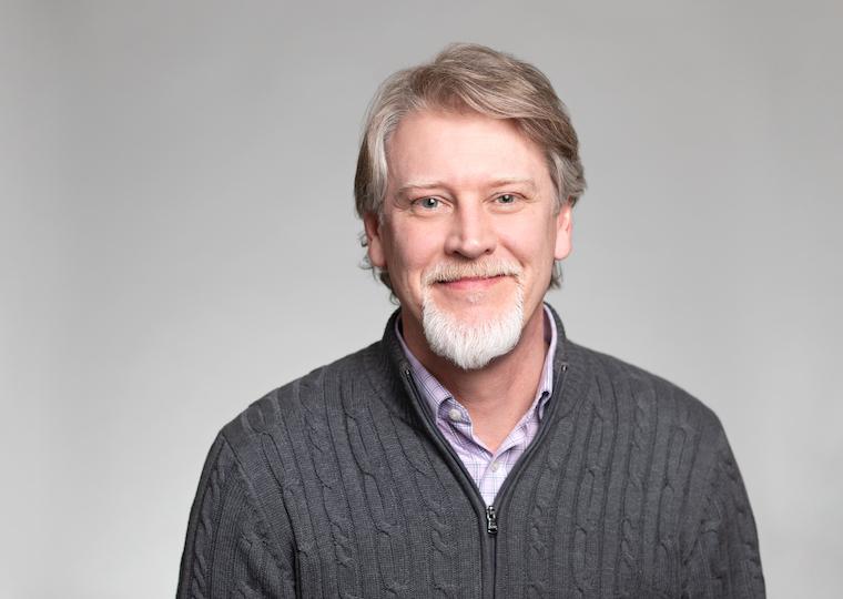 A portrait of a man wearing a sweater.