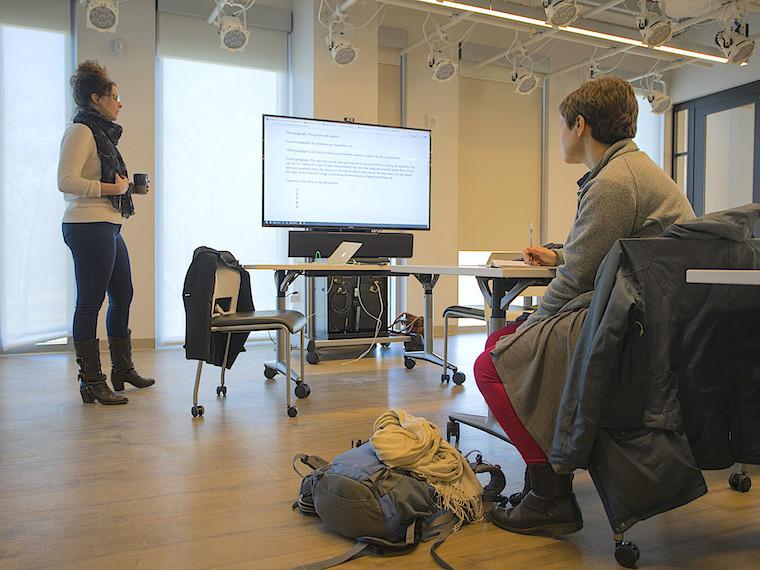 A student in a class looks at a professor.