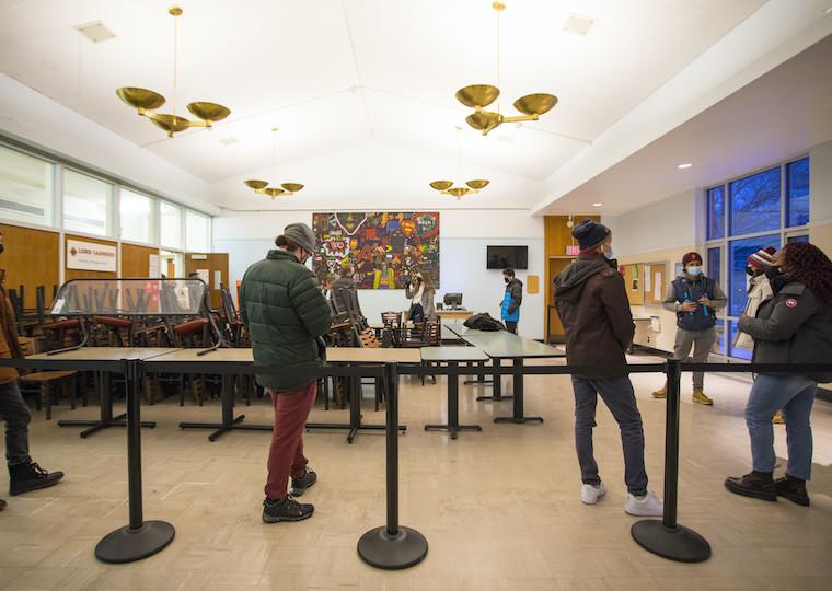 Students stand six feet apart in a line.