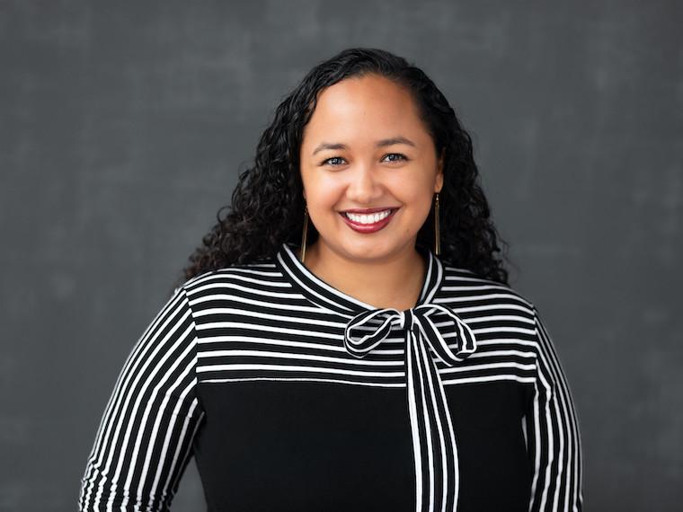 A portrait of a young woman with curly long hair.