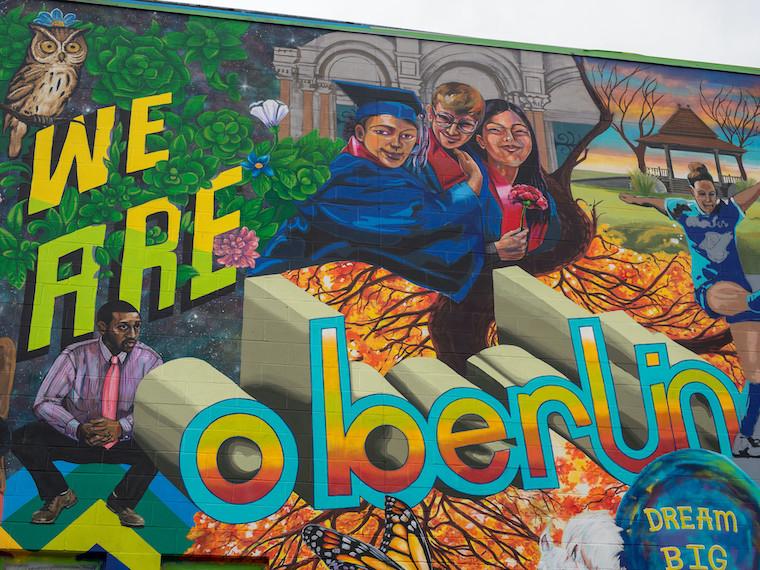 A large mural collage of an owl, people, and the words we are Oberlin.
