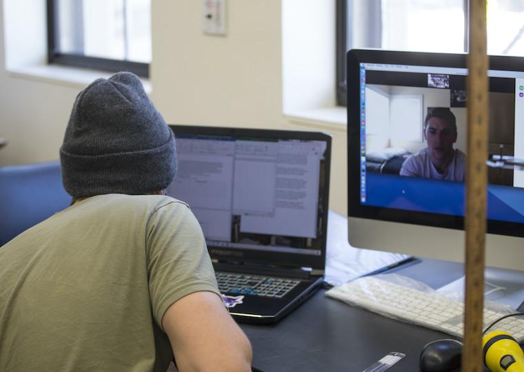 A student stares at a laptop screen.