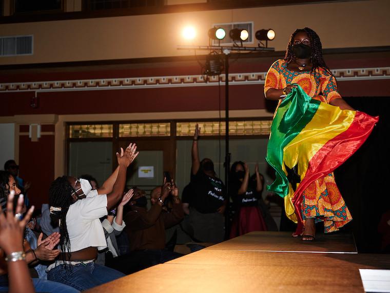 A female model holds the flag of Ghana.