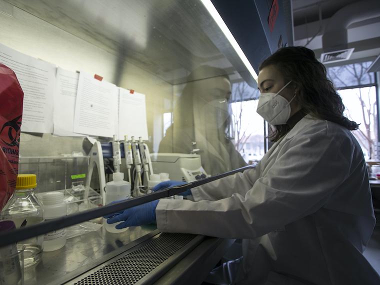 A young college students works inside of a vent.