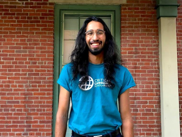 Raavi Asdar stands in front of a brick wall.