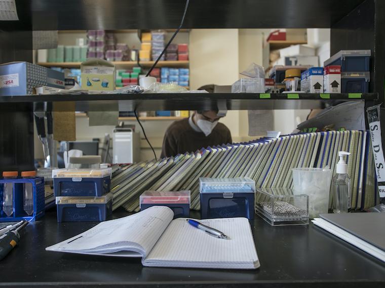 A student works in a lab surrounded by books and instruments.