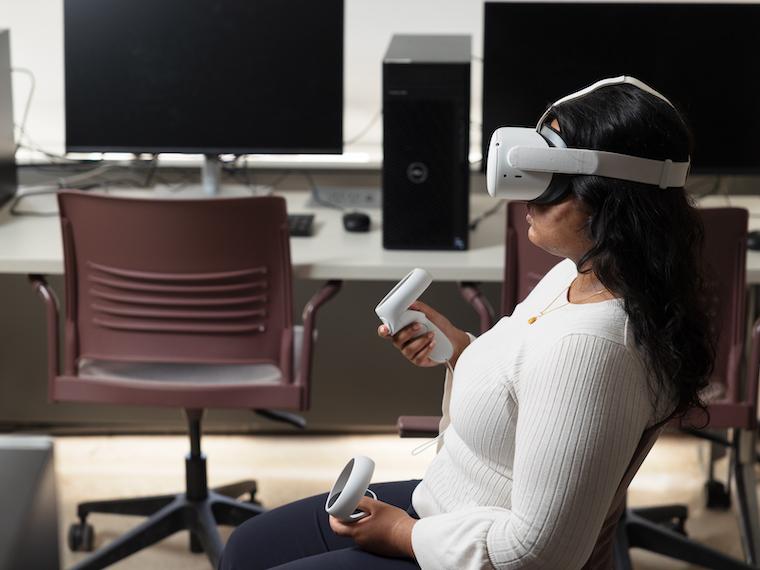 A person wearing goggles holds two joy sticks.