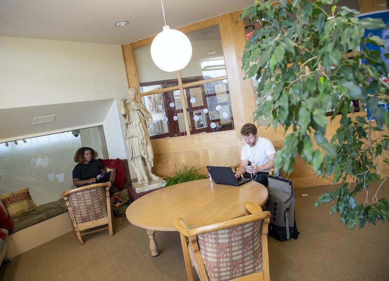 Two students study in a library nook.