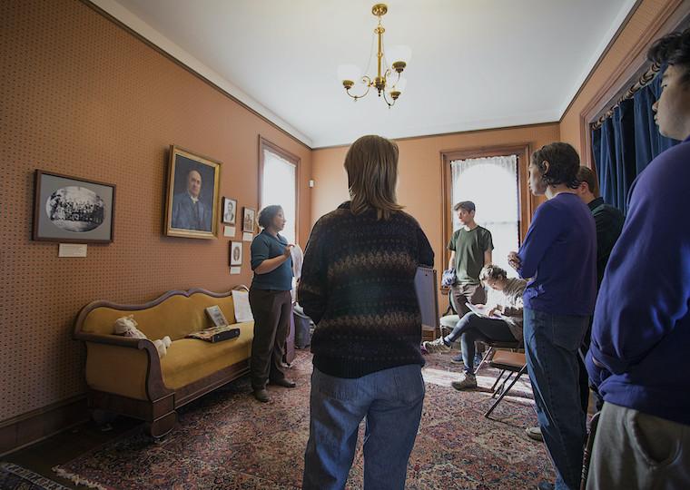 Students in a living room of a house turned into a museum.