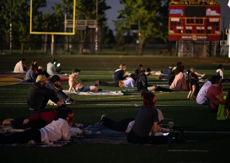 People watching a movie in a football field