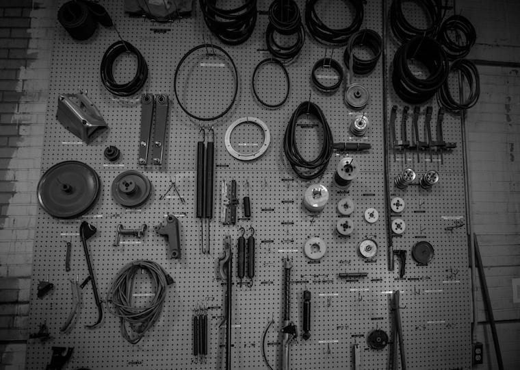 A pegboard filled with gears and belts.