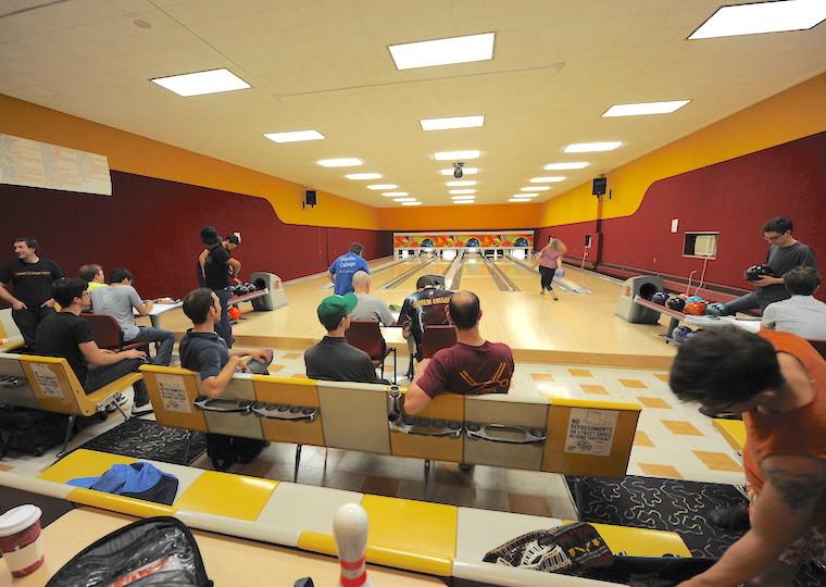 A bowling alley filled with people playing.