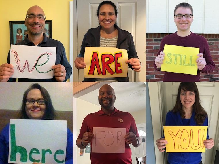 Six people hold words that spell out we are still here for you.