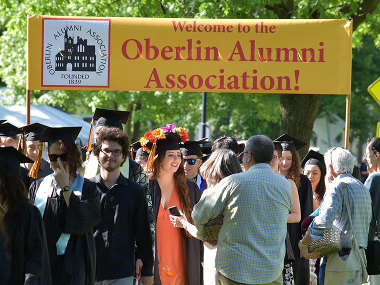 Class of 2019 walking the Alumni Association banner