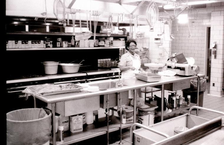 A staff member working in a kitchen on campus.
