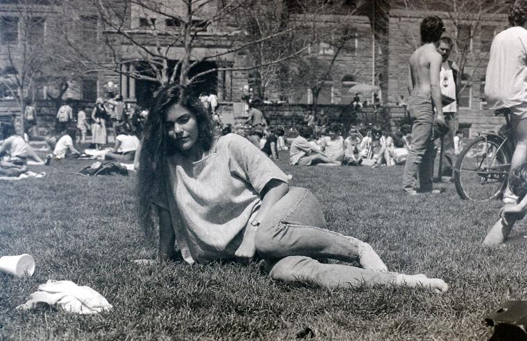 Student lounging on Wilder Bowl amid groups of other students.