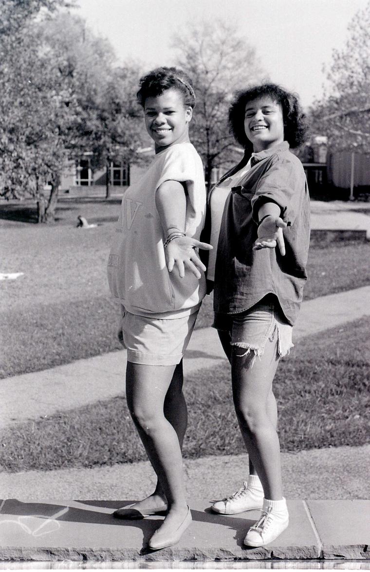 Two students pose for the camera outside.