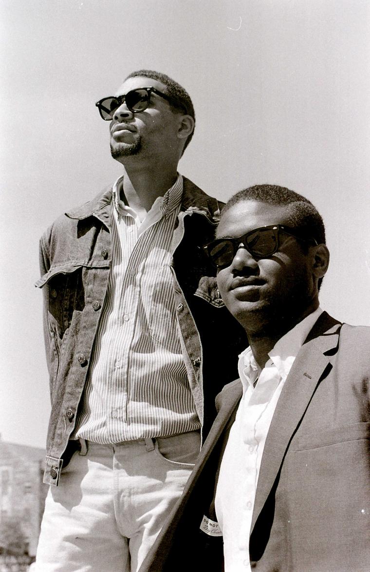 Two men in sunglasses stare into the distance.
