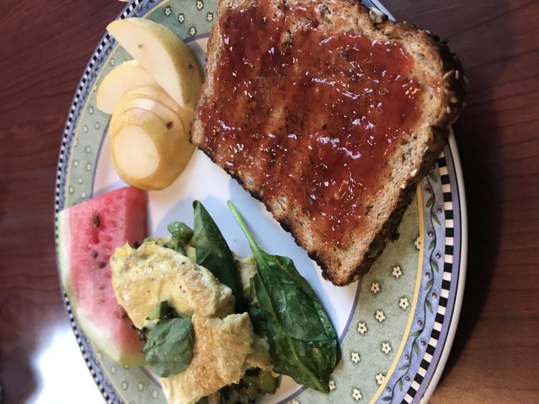 plate of food with toast and jam, omelette, pears, and watermelon