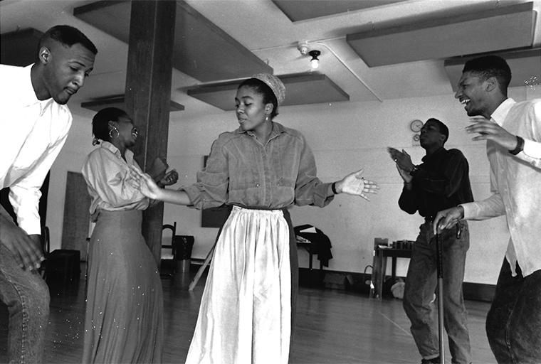 Photo of the ensemble rehearsing the call and response dance Juba, reminiscent of the Ring Shouts of the African slaves, Joe Turner's Come and Gone, by August Wilson, Directed by Caroline Jackson Smith, then artist-in-residence, Feb 1991