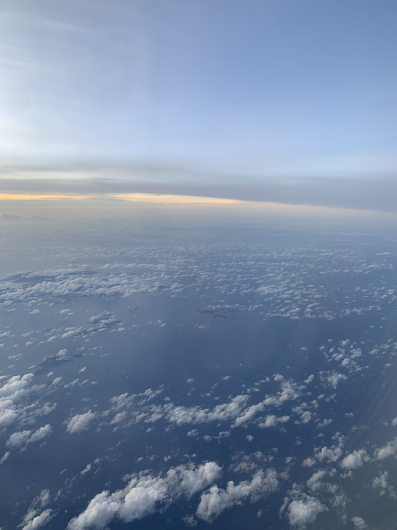 clouds and sea seen from above, with small islands in the distance