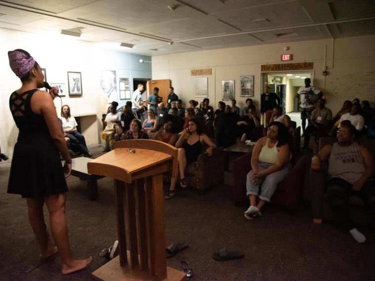 student participates in a soul session in front of a crowd at Afrikan Heritage House.