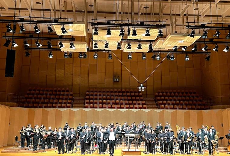 Hanyang University Wind Orchestra standing and receiving applause in a concert hall after our performance.