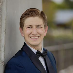 A picture of Evan Hamilton in a blue suit and bow tie.